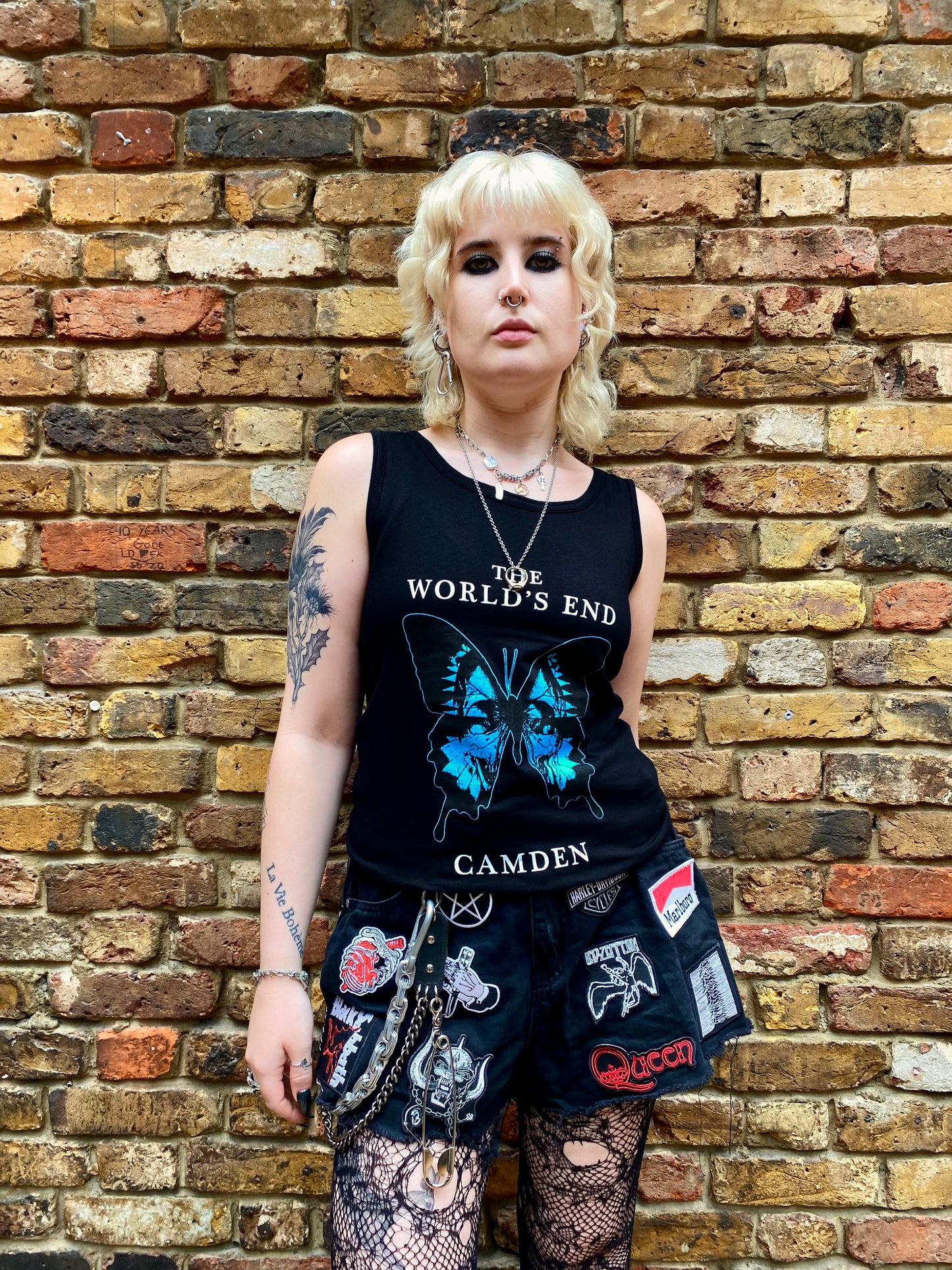 Person wearing a black tank top with a butterfly design.