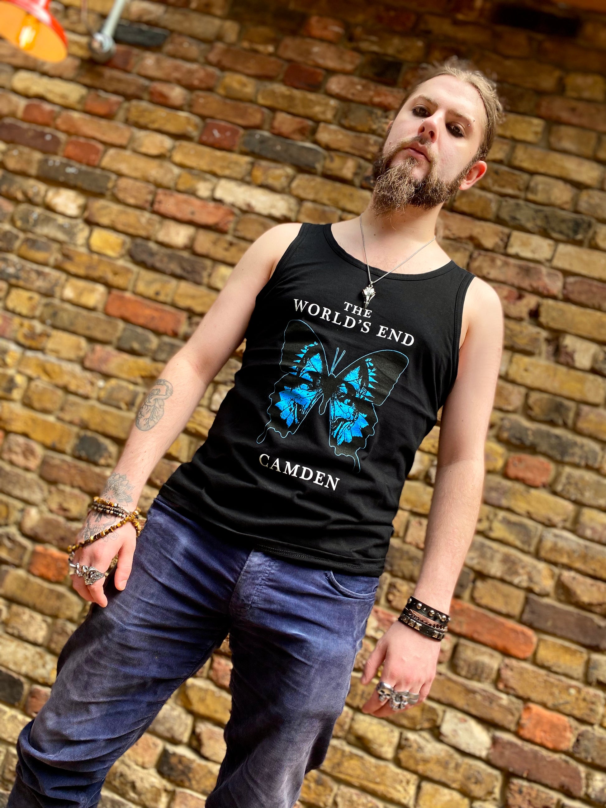 Man wearing a black tank top with 'The World's End Camden' design.