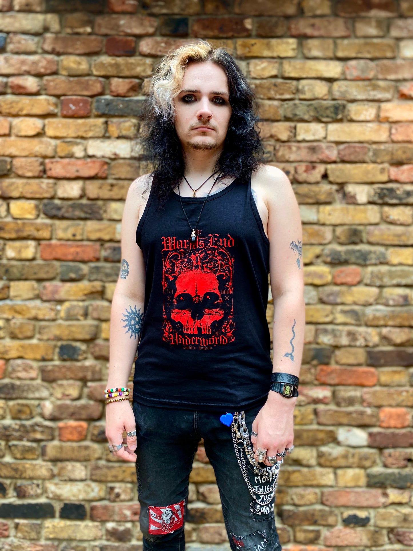 Person wearing a black tank top with red graphic design.