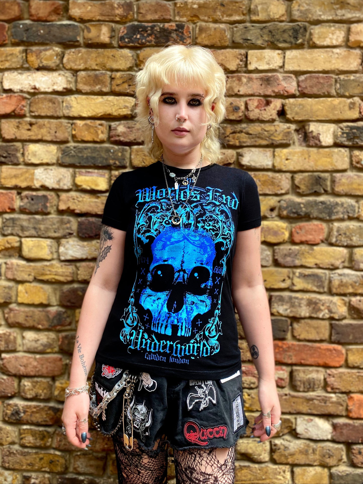Person wearing a black t-shirt with a blue World's End logo.